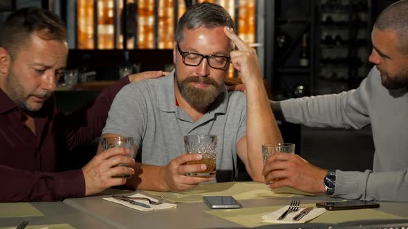 Two Mature Men Supporting Their Upset Friend While Drinking at the Bar alt