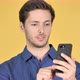 Man Using Smartphone on Yellow Background - VideoHive Item for Sale