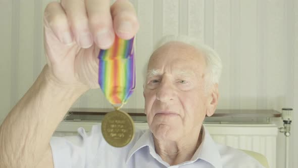 Senior man looking at an old medal