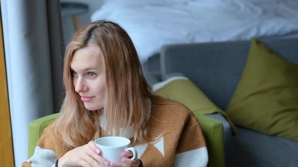 smiling woman looking out the window in a cottage