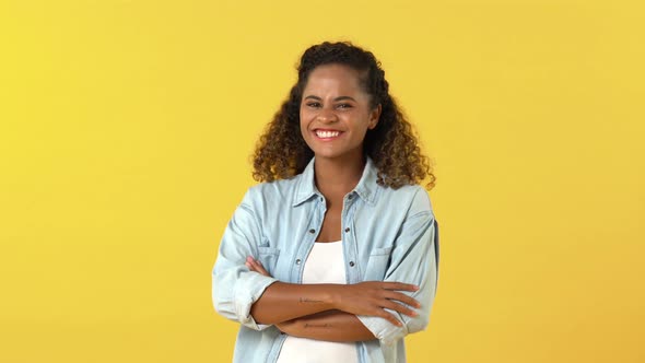 Shy young African American woman smiling and crossing arms