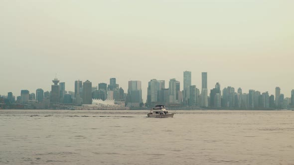 Sailing Yacht on cloudy day with Vancouver skyline in background alt