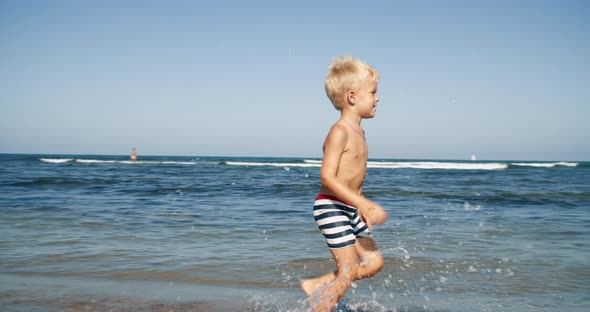 happy child running and smiling on the beach front to the sea on summer vacation alt