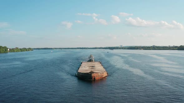 Aerial View of Towboat Tugging Barge with Grit Sailing Along River alt