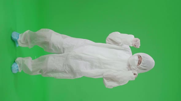 Asian Male Wear Protective Uniform PPE Wearing Medical Face Mask And Dancing In Green Screen Studio alt