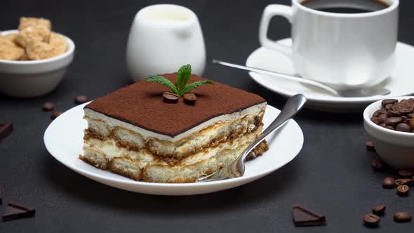 Portion of Traditional Italian Tiramisu dessert, cup of espresso coffee and coffee beans alt