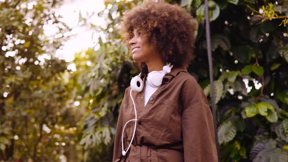 Young Woman In Sunlit Botanical Gardens alt