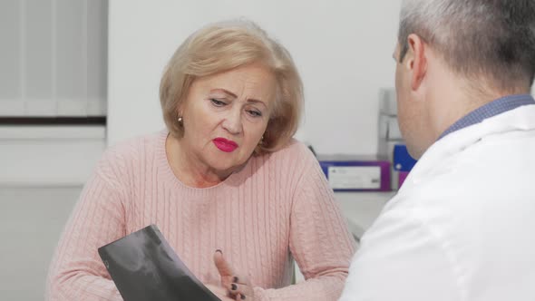 Senior Woman Receiving Bad News at Medical Appointment with Her Doctor
