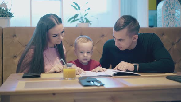 Man in Black Pullover with Wristwatch Listens To Child alt