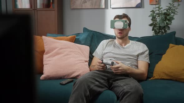 Tired Man Playing Video Games on Modern Next Gen Console with Gamepad 2021 and Vr Helmet New Era of alt