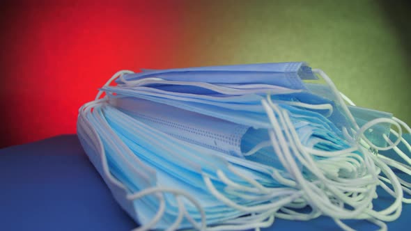 Blue Disposable Face Masks Lie on Table Under Electric Light alt