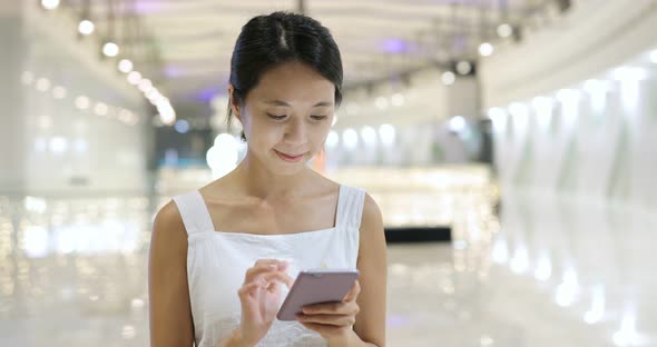 Woman use of cellphone and walking in the shopping mall alt
