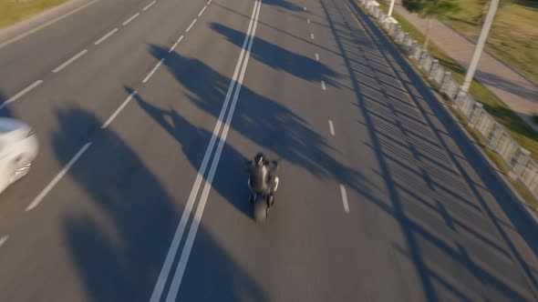 Black Lether Biker Riding on Custom Bike at Highway Traffic Urban alt