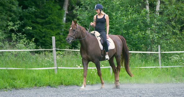 Young Woman Riding Her Arabian Horse at Farm