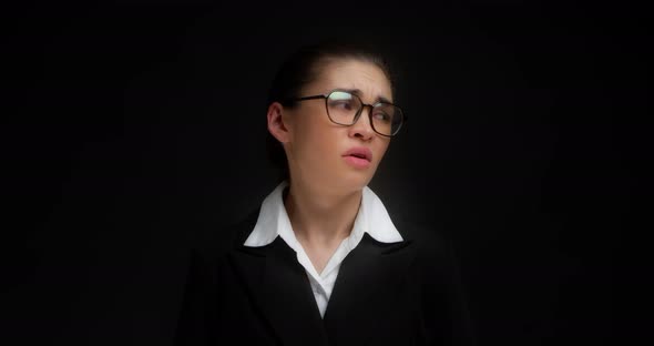 Asian Woman in Office Clothes Covers Her Ears with Her Palms alt