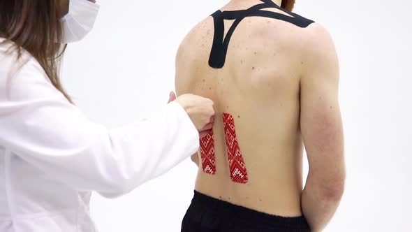 Doctor Video Footage - A Doctor Removing Kinesio Tape On The Back Of Her Patient alt