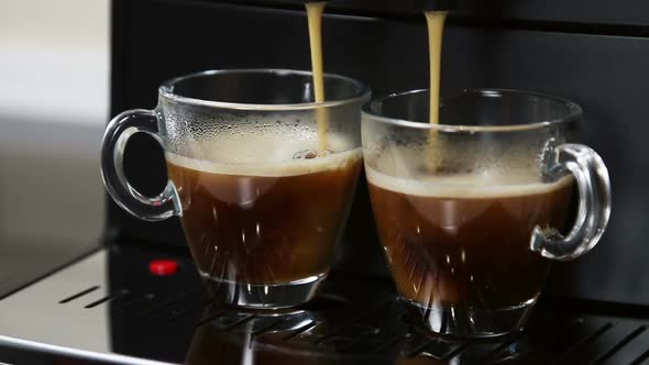 Coffee From the Coffee Machine Is Poured Into Glass Cups alt
