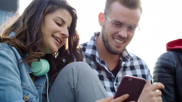 Handheld view of friends checking news by mobile phone. Shot with RED helium camera in 8K alt