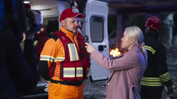 Female Journalist Interviewing Paramedic After Disaster alt