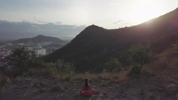 Woman Enjoys Yoga in Lotus Pose Against Mountain at Sunrise