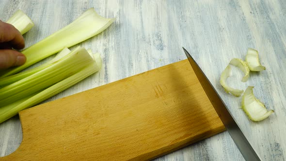 Cutting around the edges of fresh celery stalks before cooking