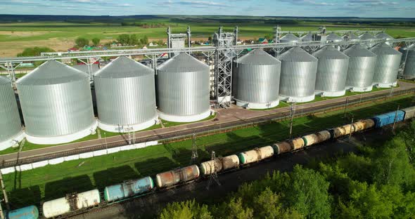 A Freight Train Passes Grain Storage Tanks