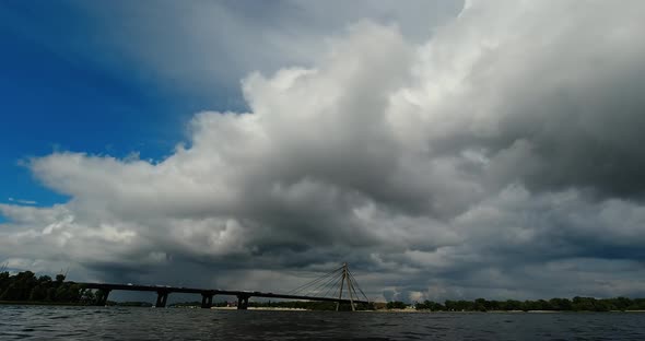 Time Lapse Clouds Over a River and a Bridge Before a Thunderstorm