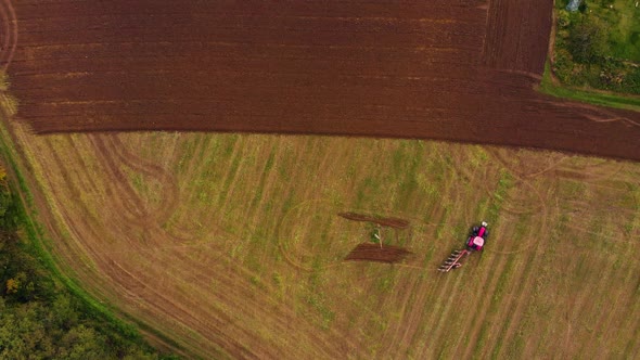 Red tractor on the farm field alt
