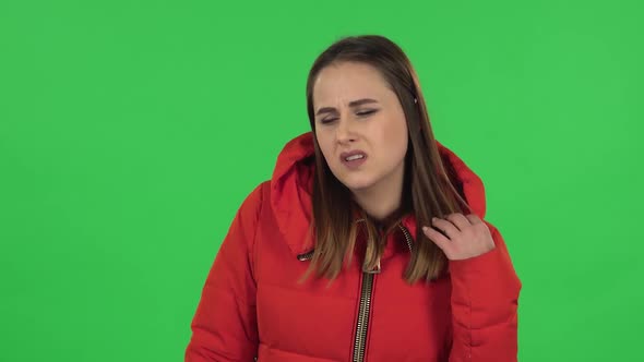 Portrait of Lovely Girl in a Red Down Jacket Is Upset and Tired. Green Screen alt