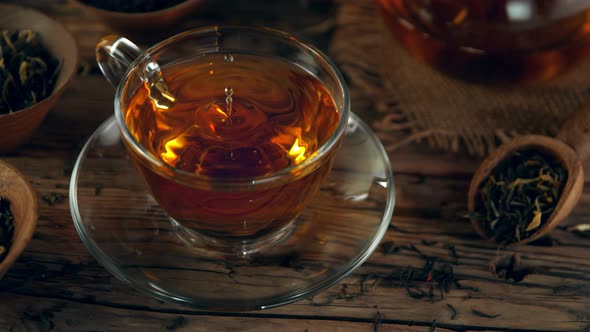 Super Slow Motion Shot of Droplet Falling Into Tea at 1000 Fps with Still Life Background alt