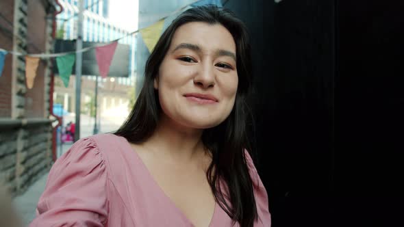 Point of View of Pretty Asian Girl Looking at Camera and Talking Making Video Call Outside in the alt