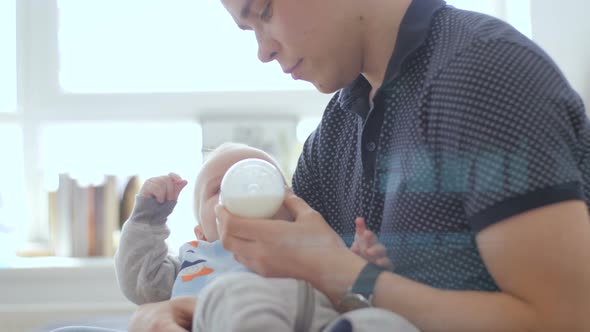 Dad Trying To Feed Baby With Milk Drink