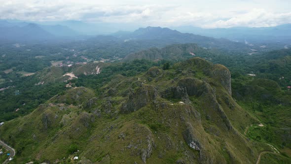 Green mountain cliffs overlooking a city in the valley of Tana Toraja in Sulawesi Indonesia. alt