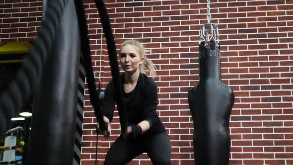 Young Fit Girl in Sports Clothes Trains in the Gym