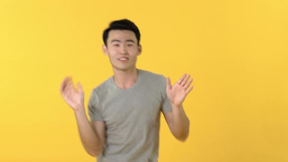 Happy funny Asian man dancing with hands waving