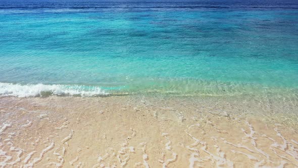 Beautiful texture of blue azure sea splashing white waves on sandy beach of coastline in Cook island alt