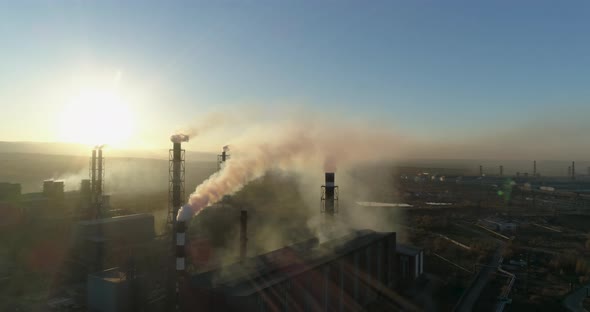 Metallurgical Production Smoke Emits From the Factory Chimney Against Sunset Sun, Aerial View alt