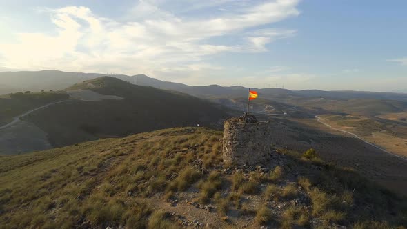 Old Abandoned Lookout Tower with a Spanish Flag and Landscape alt