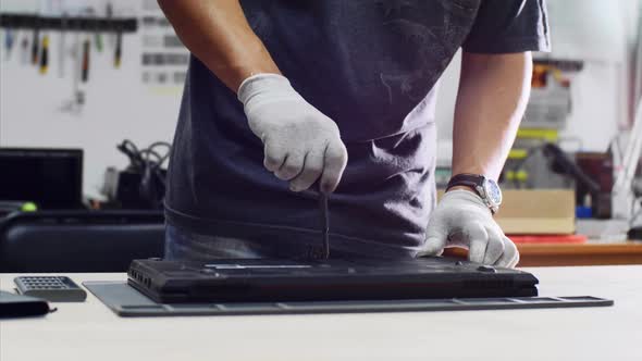 Technician Collects Laptop After Repair Screws Lid Finishes Upgrade in Workshop alt