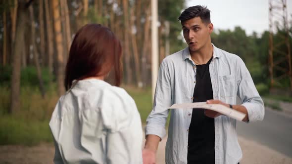 Portrait of Caucasian Young Man Talking with Angry Woman Arguing with Partner Outdoors alt