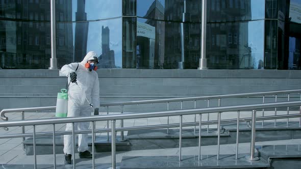 Man Disinfecter Spray Handrail Outdoor. Corona Virus. Covid-19. Coronavirus Mers alt