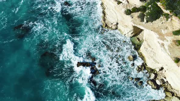 Sea Washes the Rocky Shore Above Aerial Shot Flying Over Coastline Cliffside with Blue Pure Water alt