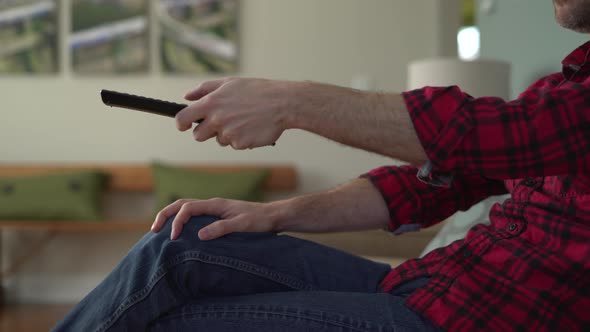Mans Hands as he is Changing Channels on TV alt