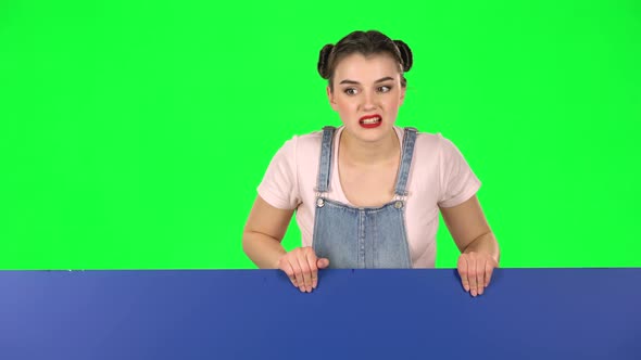 Woman Looking Out From Behind Blue Blank Placard Looks at Him and Shakes His Head Disapprovingly alt