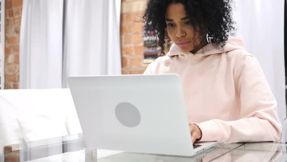 AfroAmerican Woman Working on Laptop While Sitting at Home alt