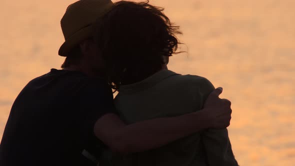 Young Traveler Couple Admiring the Sea View. Rear View of Man and Woman Hugging Each Other at Sunset