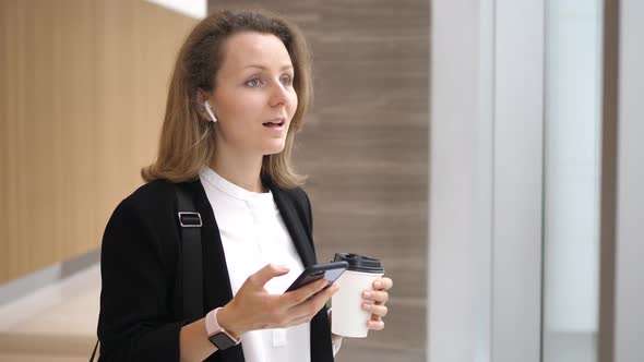 Business Woman In Wireless Earphones Airpods Headset Answering The Phone alt