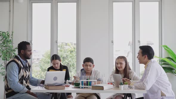 Teacher teaching and explaining chemistry experiment in science classroom alt