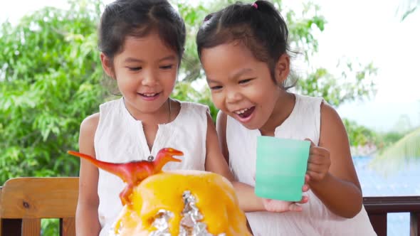 Two girls do volcano experiment at their house