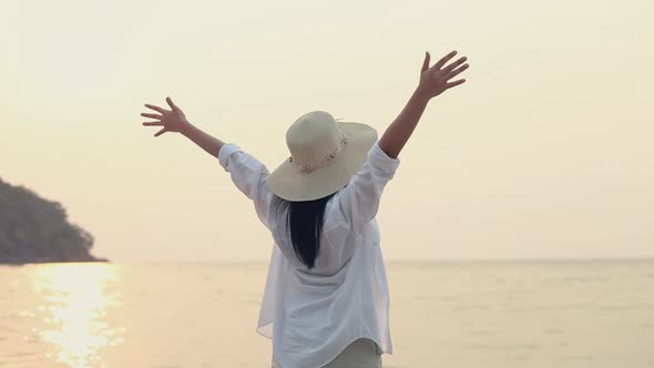 Portrait of a young woman celebrating success while standing on the beach.